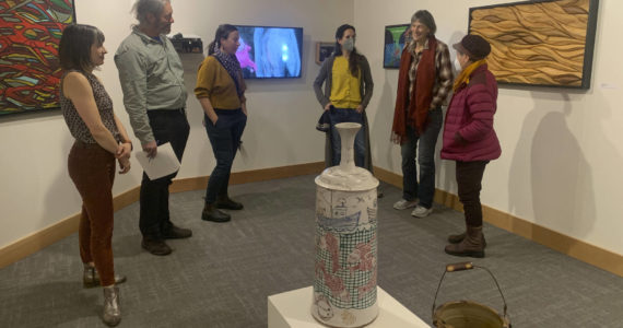 Carla Klinker Cope, far left, and Nadia Jackinski-Sethi, center, co-curators of thethe Pratt Museum & Park's show "Salmon Culture: Kachemak Bay Connections," discuss the show in a talk on Friday, Nov. 3, 2022, at the museum. (Photo by Christina Whiting)