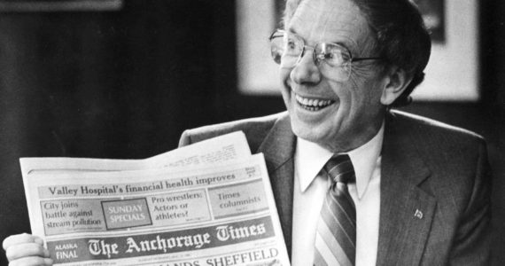 Former Alaska Gov. Bill Sheffield smiles as he holds a The Anchorage Times newspaper in his Capitol office in Juneau, Alaska, on Aug. 5, 1985, after he survived an impeachment effort during July and August 1985. A statement provided by friends says he died Friday, Nov. 4, 2022, at his home in Anchorage. He was 94. Sheffield was governor from 1982 to 1986. (Brian Wallace/The Juneau Empire via AP, File)