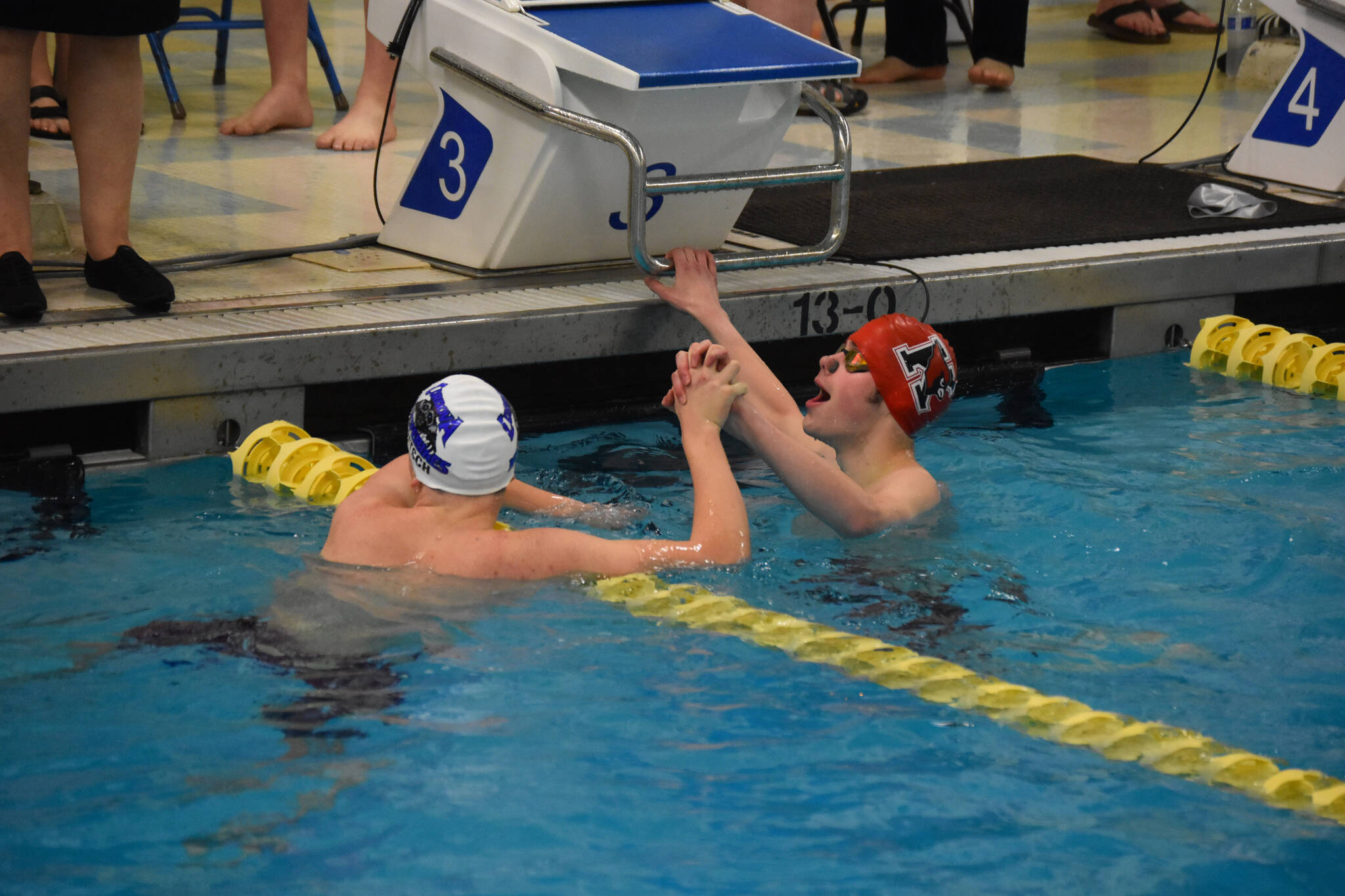 Samuel Anderson, of Kenai, and Trent Fritsch, of Cordova, celebrate after completing the 100-yard backstroke during finals at the ASAA State Swim & Dive Championships on Saturday, Nov. 5, 2022, at Bartlett High School in Anchorage, Alaska. (Jake Dye/Peninsula Clarion)