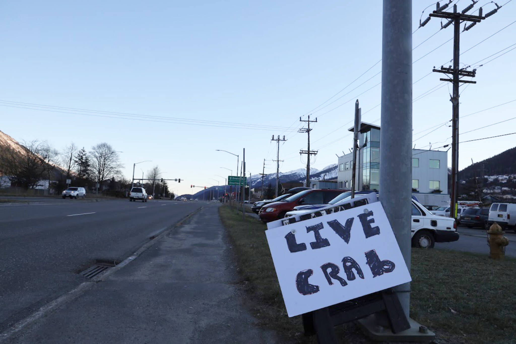 A foam sign with the words “live crab” written with a black marker sits at the entrance of Aurora Harbor along Egan Drive Monday afternoon. Charlie Blattner, a Juneau-based Dungeness crab fisherman, was berthed at Aurora Harbor selling live Dungeness crabs he caught in the past few days around the Juneau area. (Clarise Larson / Juneau Empire)