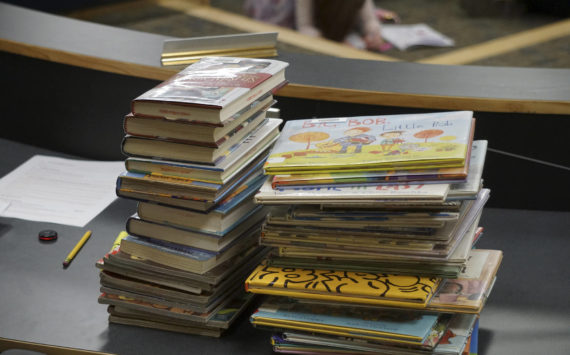 Some of the Homer Public Library books a citizens group has asked be removed from the children's section lie on a table at the meeting of the Library Advisory Board on Nov. 15, 2022, in the Cowles Council Chambers at Homer City Hall in Homer, Alaska. (Photo by Michael Armstrong/Homer News)