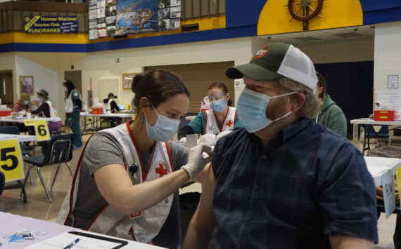 Anna Lewald, left, a registered nurse at South Peninsula Hospital, gives Dave Aplin, right, an influenza vaccine at a flu and Pfizer COVID-19 vaccine clinic Friday, Oct. 15, 2021, at Homer High School in Homer, Alaska. (Photo by Michael Armstrong/Homer News)