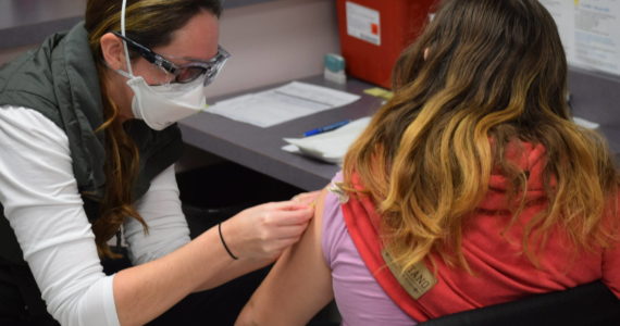 Nurse Sherra Pritchard gives Madyson Knudsen a bandage at the Kenai Public Health Center after the 10-year-old received her first COVID-19 vaccine on Friday, Nov. 5, 2021. (Camille Botello/Peninsula Clarion file)