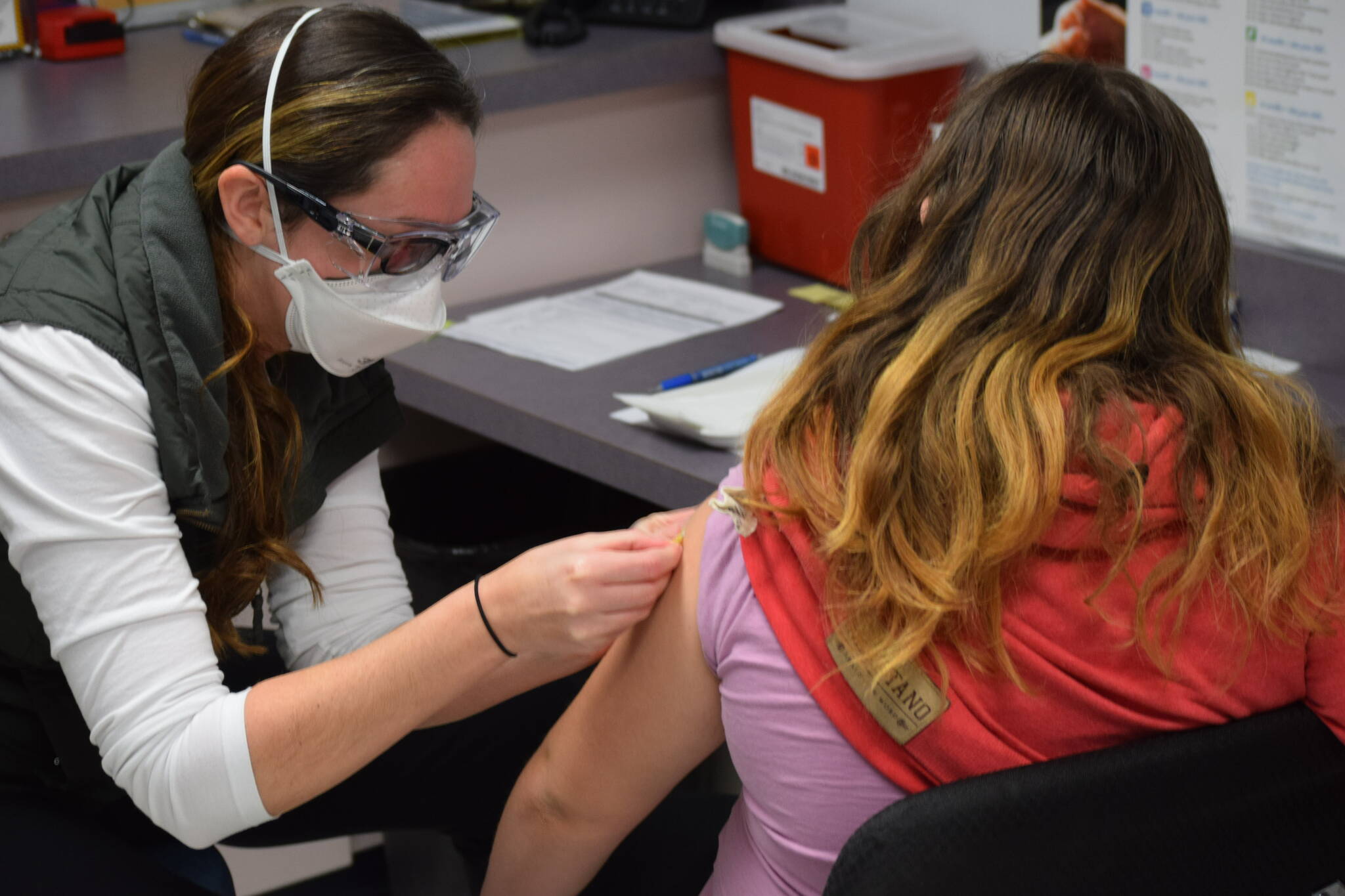 Nurse Sherra Pritchard gives Madyson Knudsen a bandage at the Kenai Public Health Center after the 10-year-old received her first COVID-19 vaccine on Friday, Nov. 5, 2021. (Camille Botello/Peninsula Clarion file)