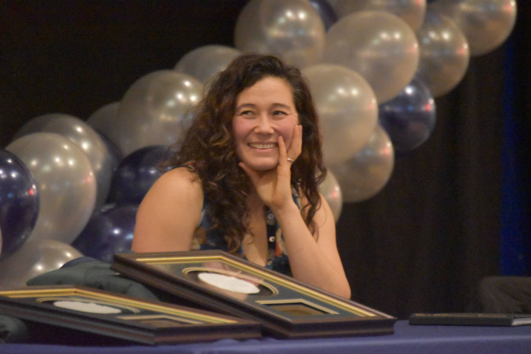 Tela O’Donnell-Bacher laughs at a story being told by Neldon Gardner while both were being inducted to the National Wrestling Hall of Fame following the duel wrestling meet on Tuesday, Nov. 22, 2022, at Soldotna High School in Soldotna, Alaska. (Jake Dye/Peninsula Clarion)