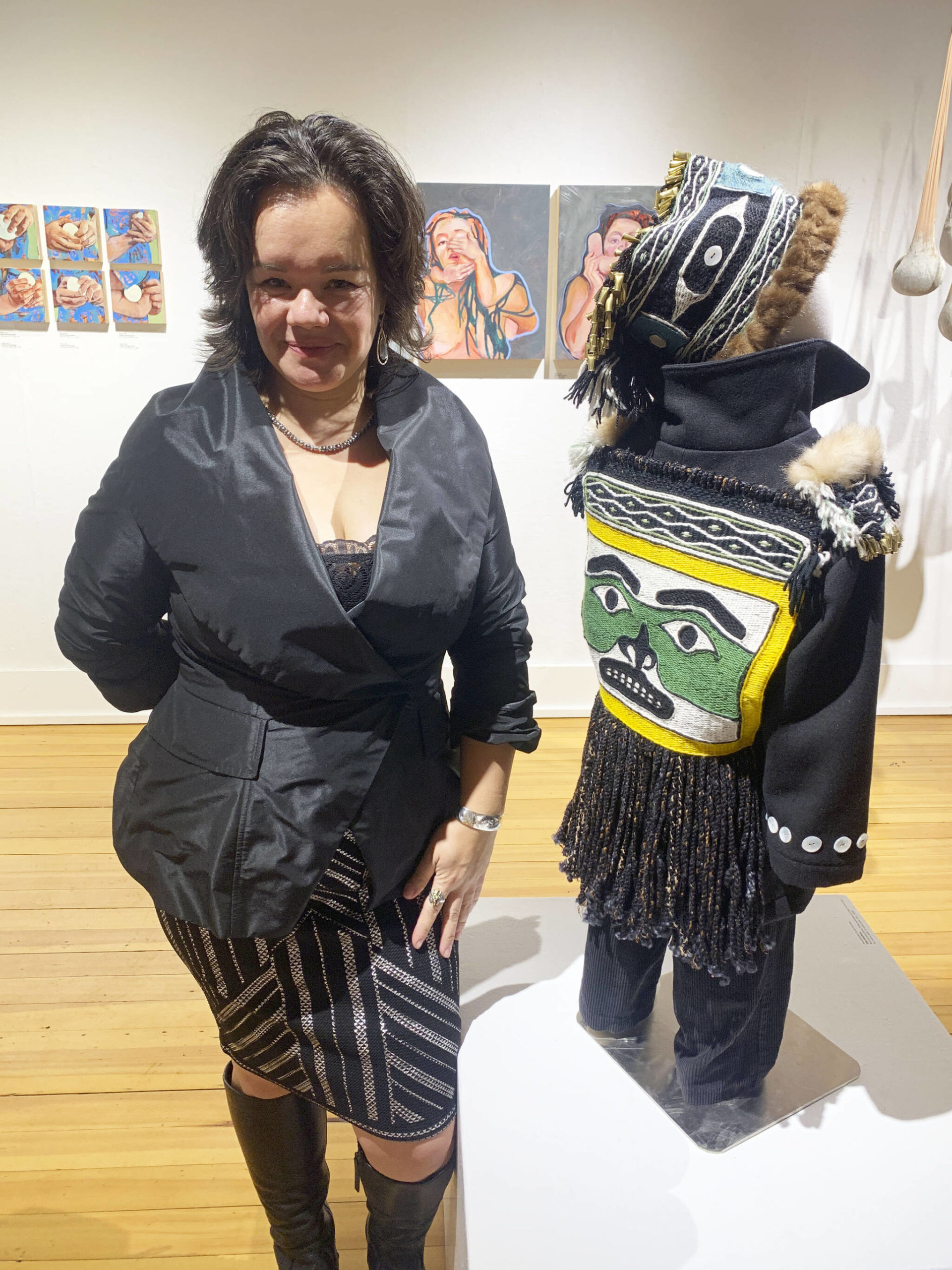 Juneau artist Lily Wooshkindein Da.Aat poses with her work, Little Watchman, at the opening this month of the exhibit Mother at Bunnell Street Arts Center. (Photo by Christina Whiting)