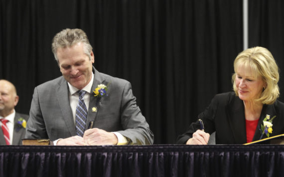 Gov. Mike Dunleavy, seated left, and Lt. Gov. Nancy Dahlstrom sign their oaths of office during the inauguration ceremony, Monday, Dec. 5, 2022, in Anchorage, Alaska. Dunleavy, a Republican, last month became the first Alaska governor since Democrat Tony Knowles in 1998 to win back-to-back terms. (AP Photo/Mark Thiessen)