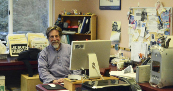 Michael Armstrong poses at his desk in February 2015 at the Homer News in Homer, Alaska. (Photo by McKibben Jackinsky)