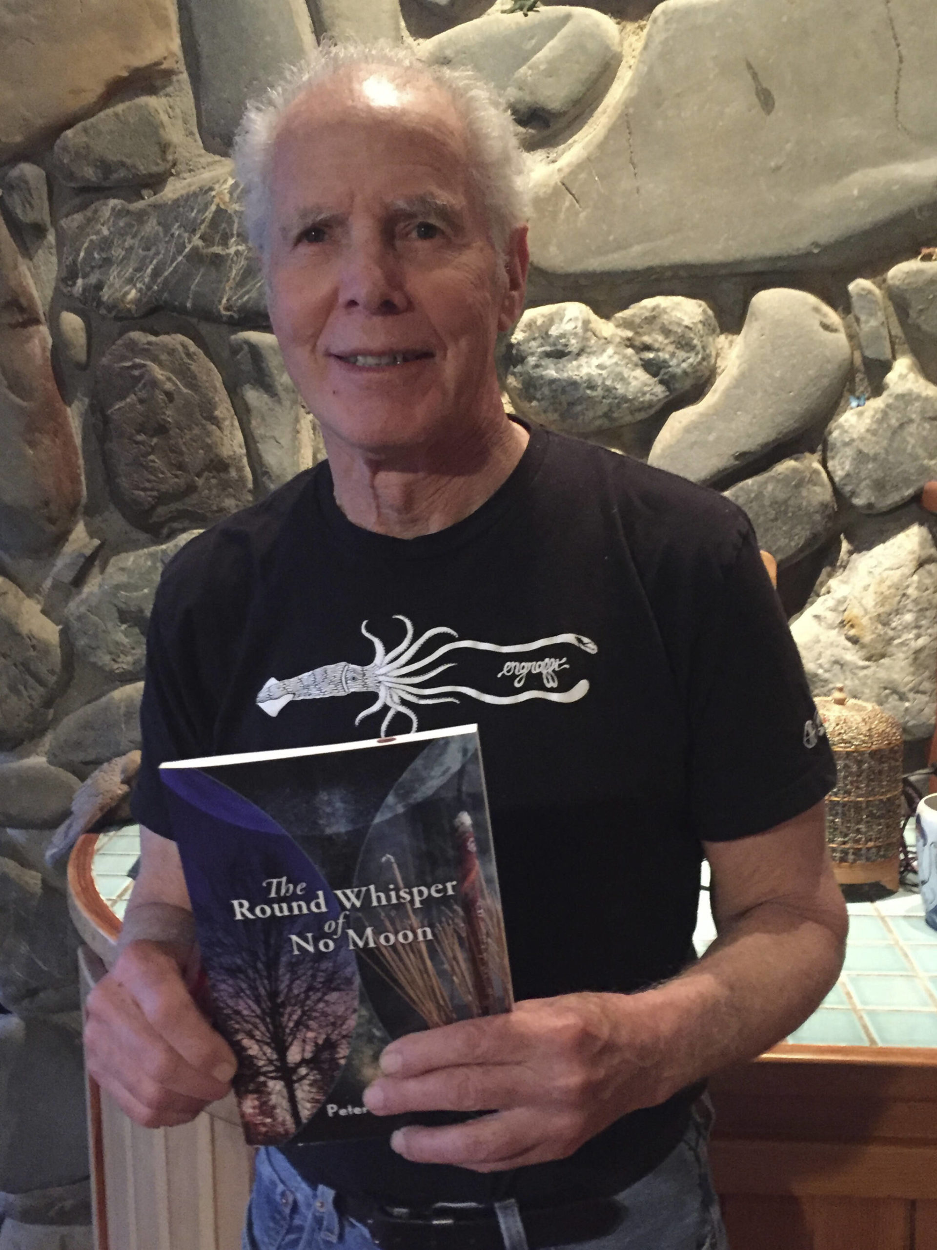 Peter Kaufmann holds a copy of his book of poetry, "The Round Whisper of No Moon." (Photo provided)