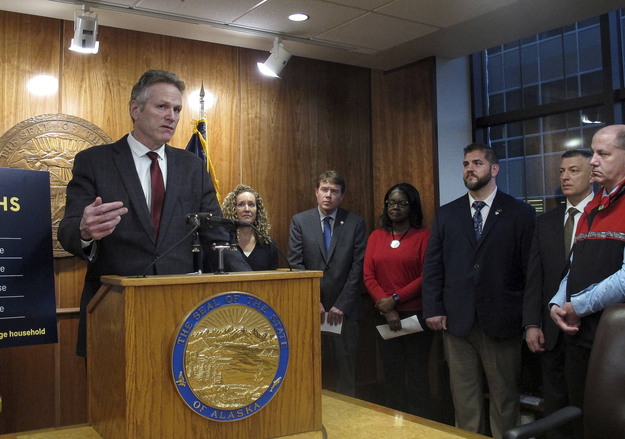 Alaska Gov. Mike Dunleavy, left, speaks to reporters during a news conference on his proposed budget, Thursday, Dec. 15, 2022, in Juneau, Alaska, with members of his Cabinet also pictured. Dunleavy called the budget a starting point for discussions with lawmakers, who convene for a new legislative session in January. (AP Photo/Becky Bohrer)