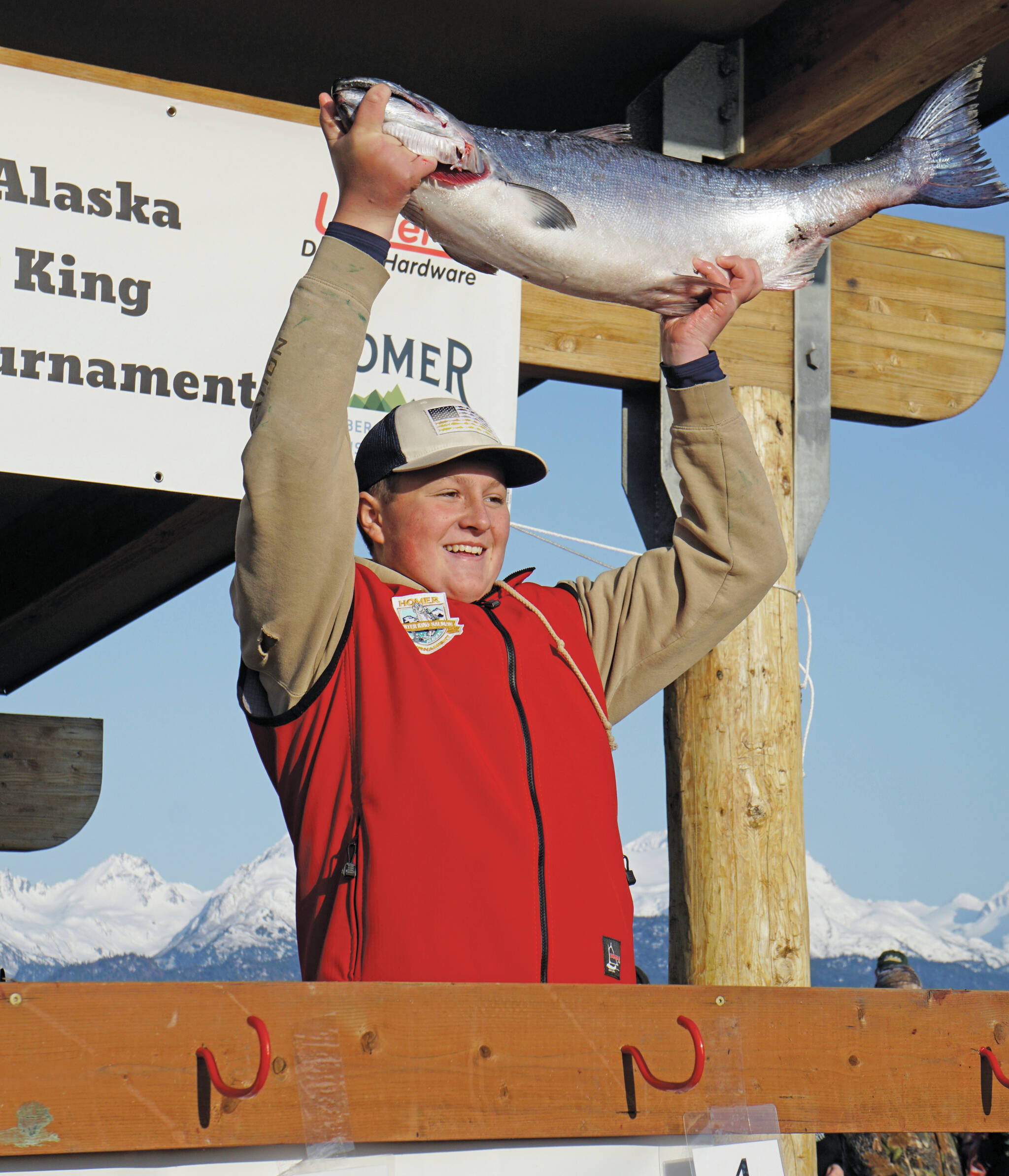 Weston Marley holds up the 27.38-pound winter king salmon he caught to win the 28th annual Homer Winter King Salmon Tourament on Sunday, April 10 in Kachemak Bay. Marley, 15, fished on the Fly Dough with his father, Jay Marley, and brother, Andrew Marley. It’s the second year a Marley boy won the tournament, with Andrew taking first place for a 25.62-pound king in 2022. (Photo by Michael Armstrong/Homer News)