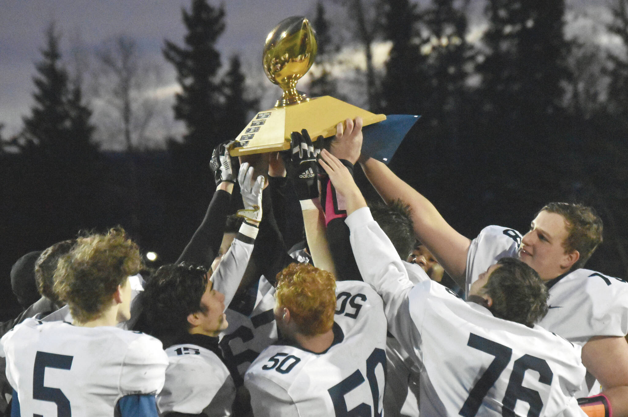 Homer hoists the Division III state championship trophy Saturday, Oct. 15, at Service High School in Anchorage. (Photo by Jeff Helminiak/Peninsula Clarion)