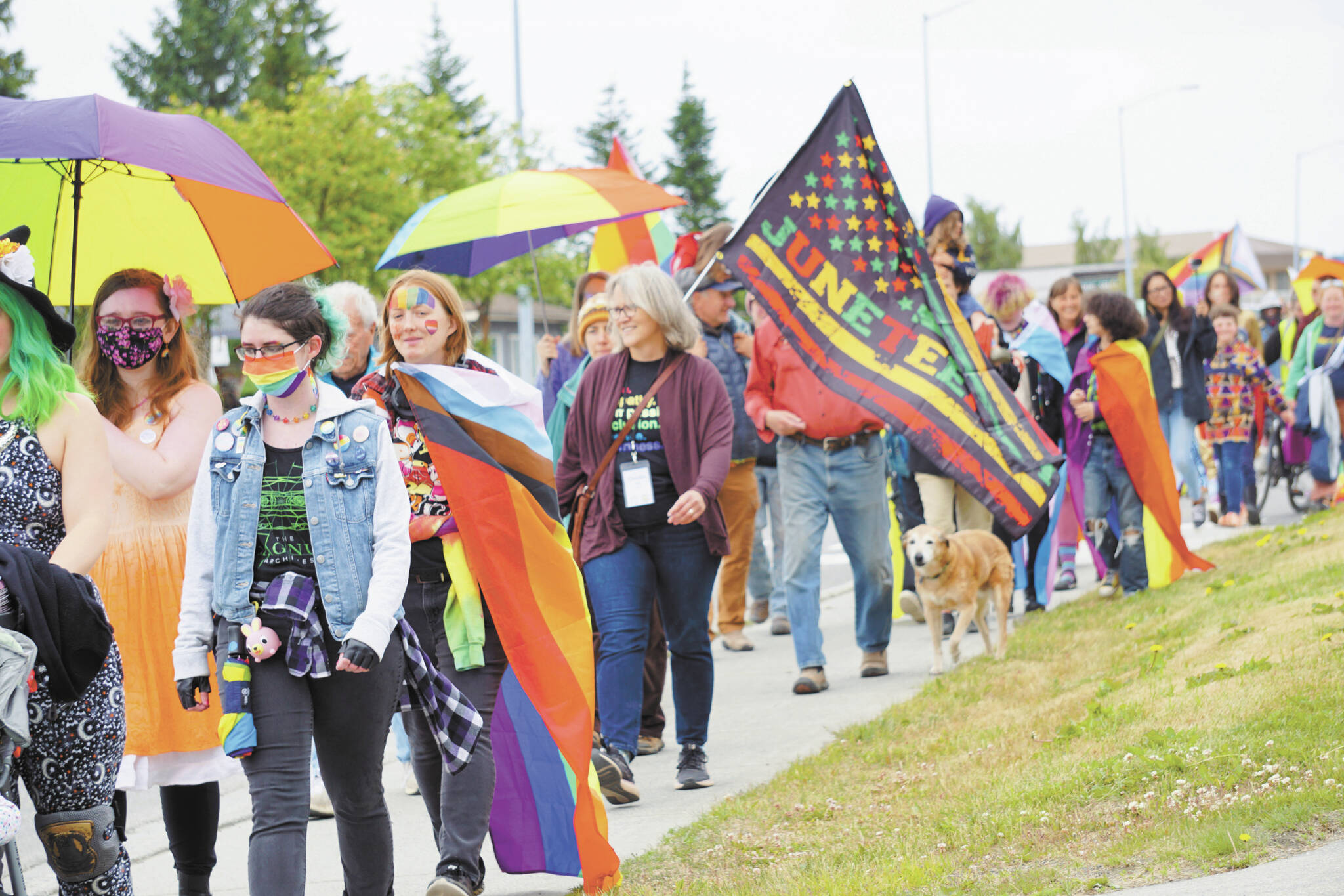 Marchers wearing Pride rainbow colors and carrying Juneteenth flags march in the Pride-X-Juneteenth parade on Saturday, June 18, on Pioneer Avenue. (Photo by Michael Armstrong/Homer News)