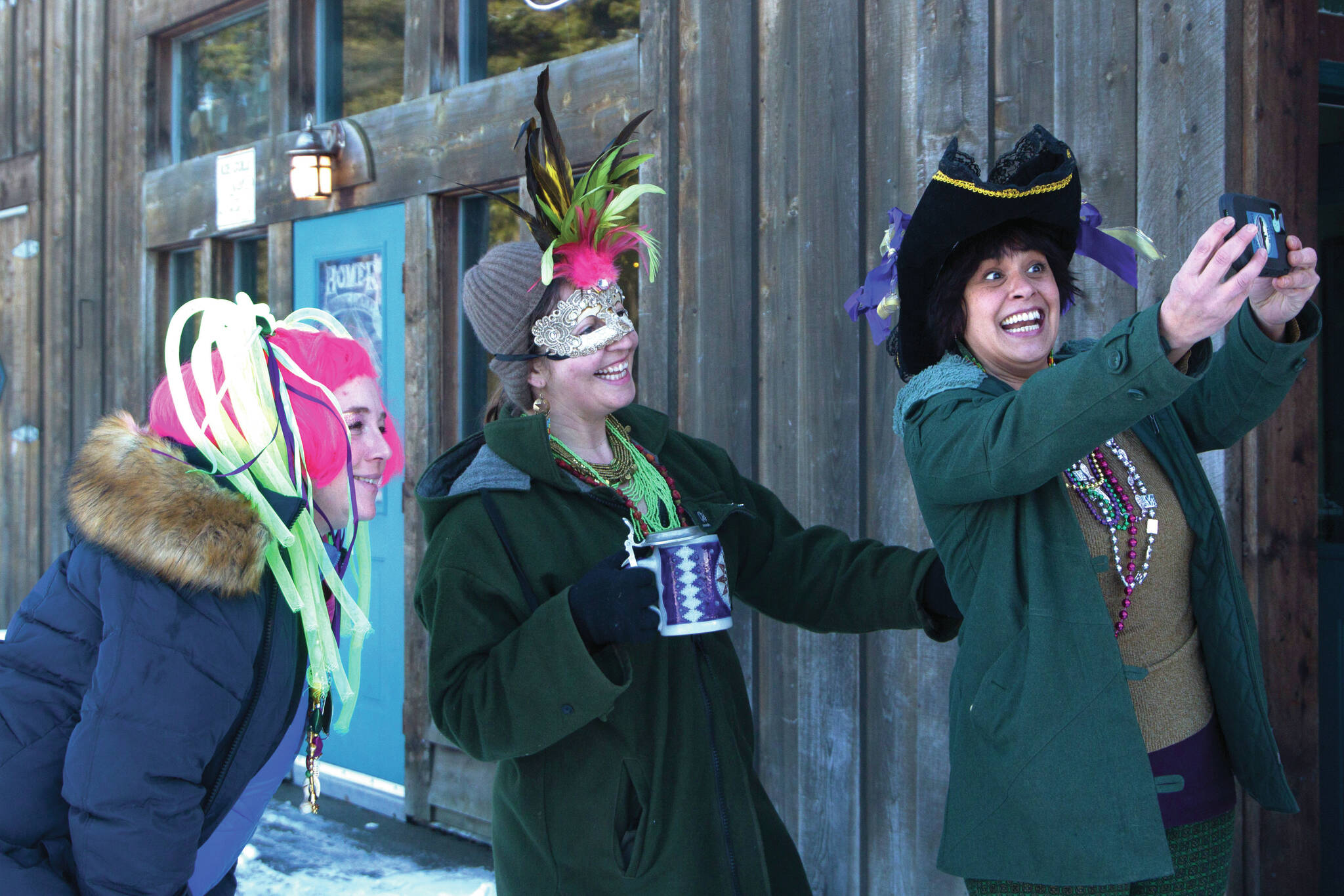 These three ladies are all smiles for the Krewe of Gambrinus Winter Carnival and Mardi Gras parade, Feb. 17. (Photo by Sarah Knapp/Homer News)