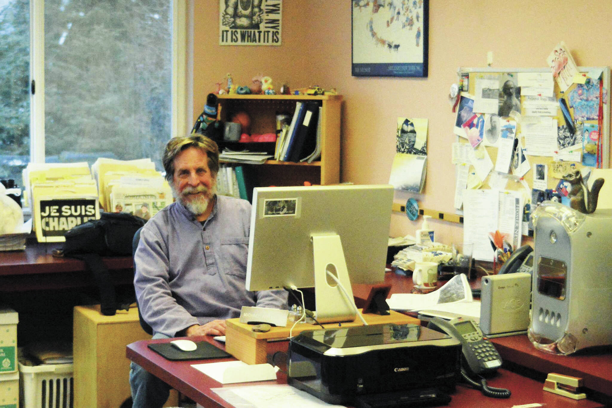 Michael Armstrong poses at his desk in February 2015 at the Homer News in Homer. (Photo by McKibben Jackinsky)