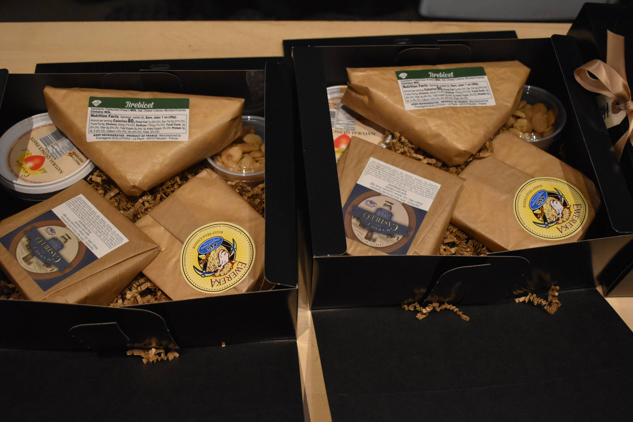 Two Cheese of the Month subscription boxes are filled with artisinal cheeses and sides on Friday, Jan. 6, 2023 at Lucy’s Market in Soldotna, Alaska. (Jake Dye/Peninsula Clarion)