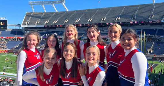 Members of the Kenai Central High School cheerleading team (back row, left to right): Kaitlyn Taylor, Sylvia McGraw, Malena Grieme, Maya Montague, Cali Holmes and Genesis Trevino; (front row, left to right): Makenzie Harden, Ella Romero and Brooklyn Reed stand for a photo at the Cheez-It Citrus Bowl on Monday, Jan. 1, 2023, at Camping World Stadium in Orlando, Florida. (Photo courtesy Brianna Force)