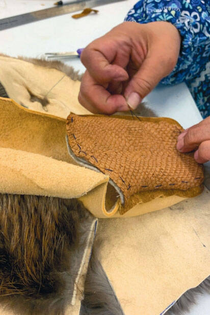Photo provided 
June Pardue sews a tanned salmon skin vamp onto bison hide with sea otter fur lying beneath.