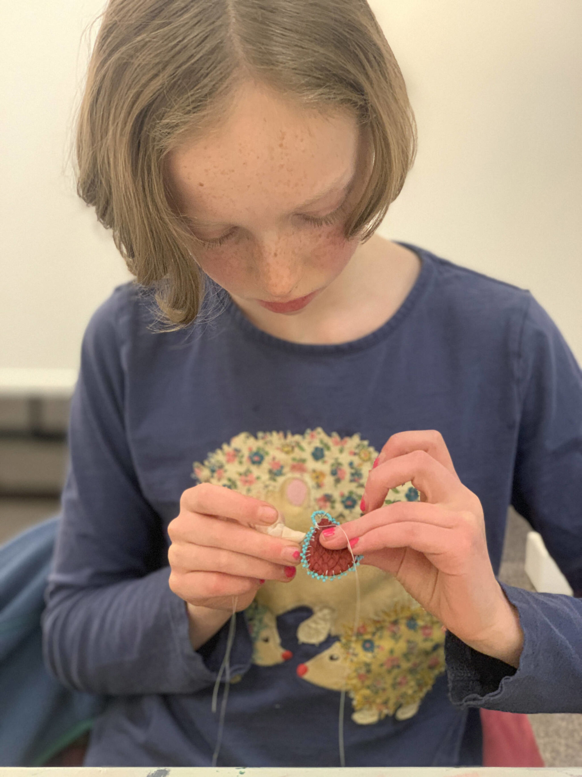 Freya Bartlett makes earrings from salmon skin leather during a recent workshop with artist June Pardue at HCOA. (Photo by Christina Whiting/Homer News)