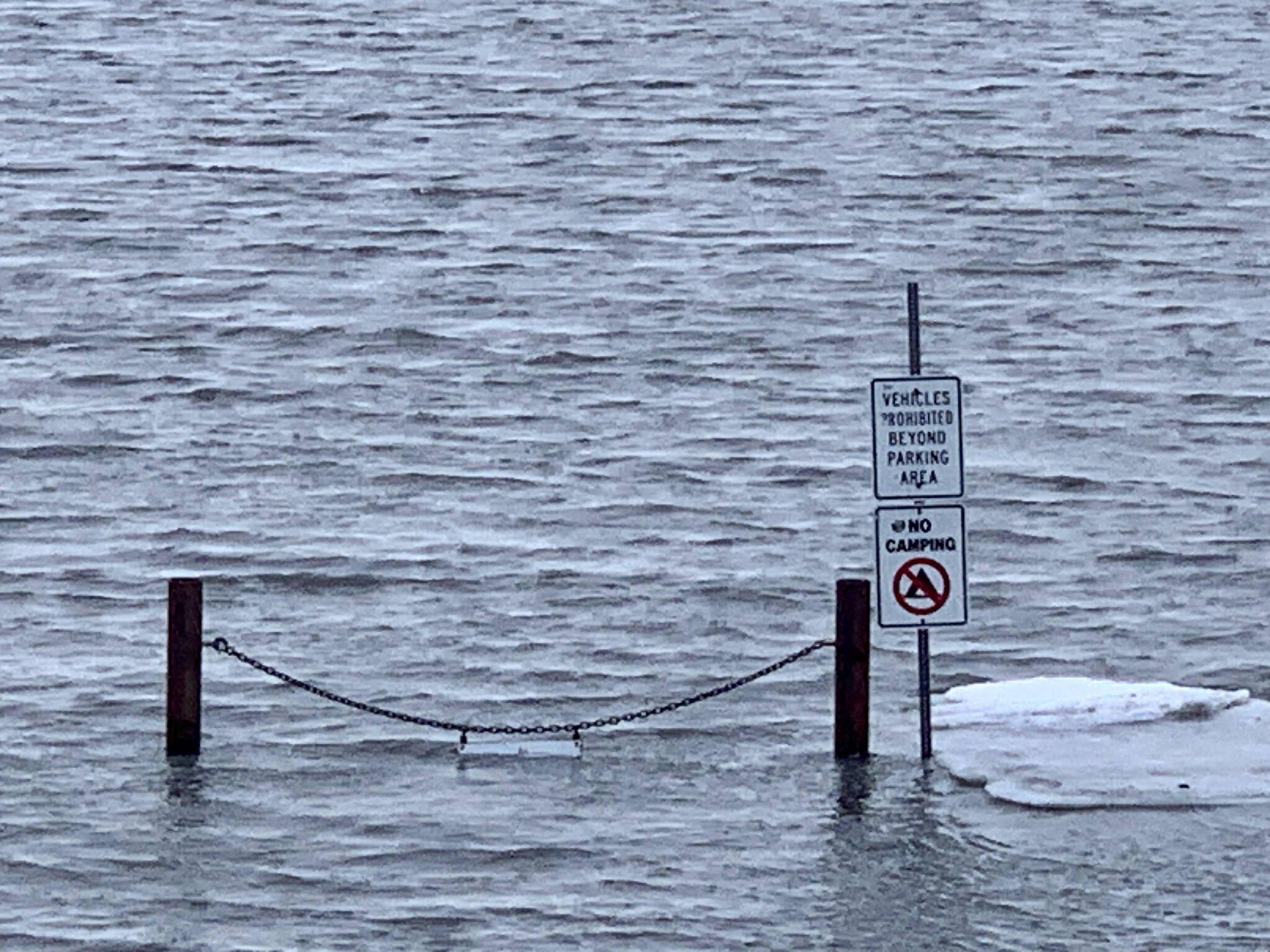 High tide washes into a parking area along the Homer Spit Road, Jan. 22, 2023, in Homer, Alaska. (Photo by Christina Whiting)