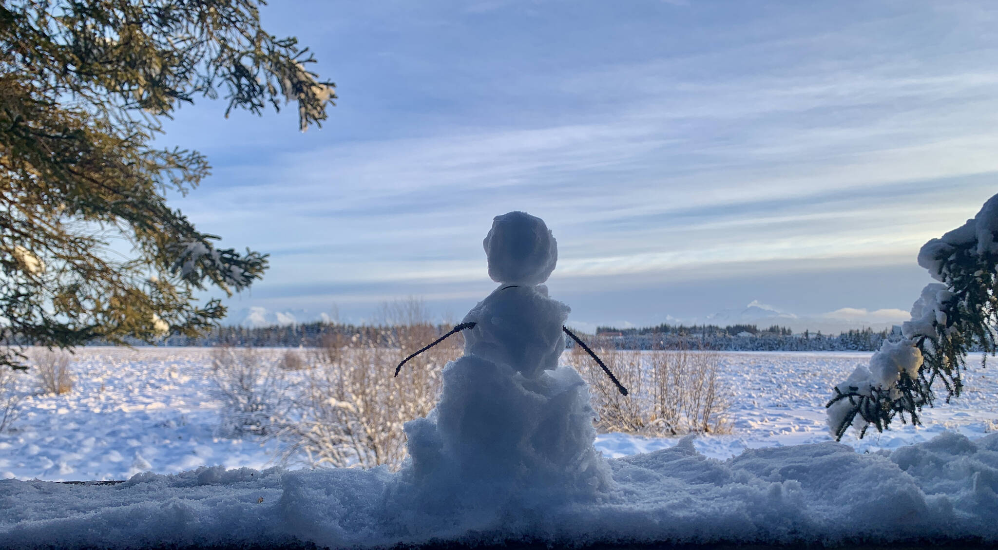 A tiny snowman looks out over Beluga Slough from the Calvin and Coyle trail, Jan. 21, 2023, in Homer, Alaska. (Photo by Christina Whiting)