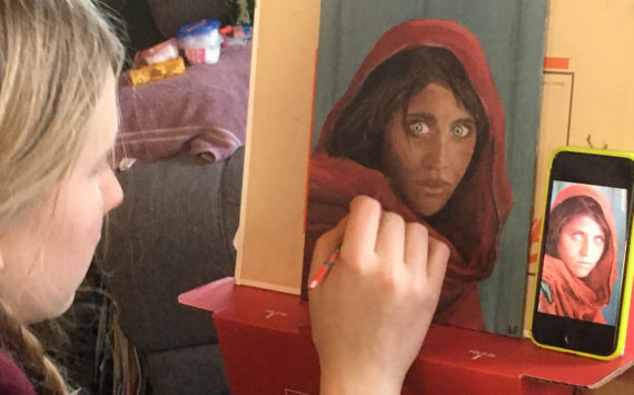 Homer youth artist Leah Dunn works on a painting from the famous 1984 Afghan Girl, originally portrayed on the cover of National Geographic. (Photo provided by Leah Dunn)