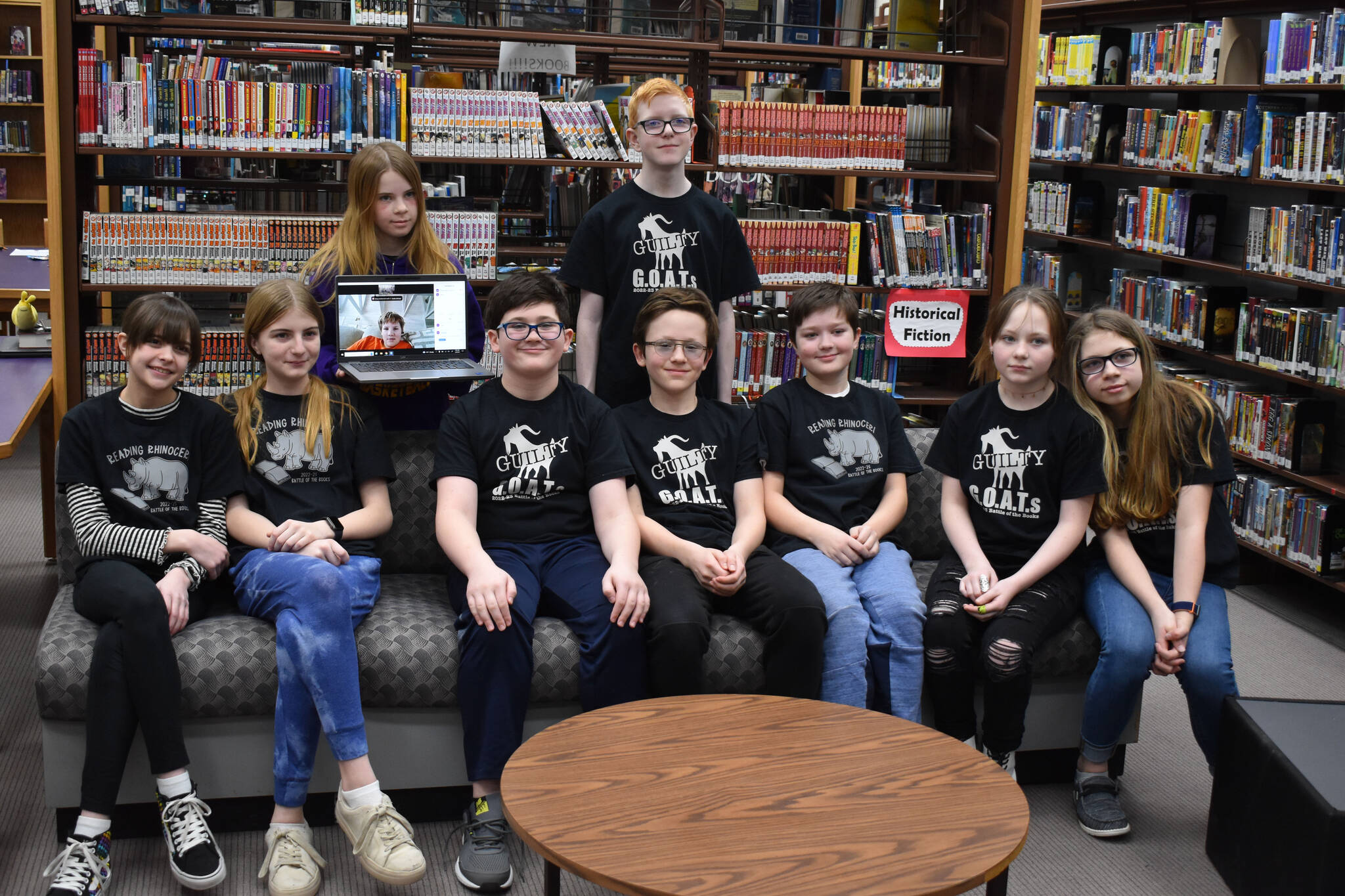 Kenai Middle School Battle of the Books teams, the Reading Rhinoceri and the Guilty GOATs, gather for a photo after their first match during Kenai Peninsula Borough School District Middle School Battle of the Books competition on Thursday, Feb. 9, 2023, at Kenai Middle School in Kenai, Alaska. (Jake Dye/Peninsula Clarion)