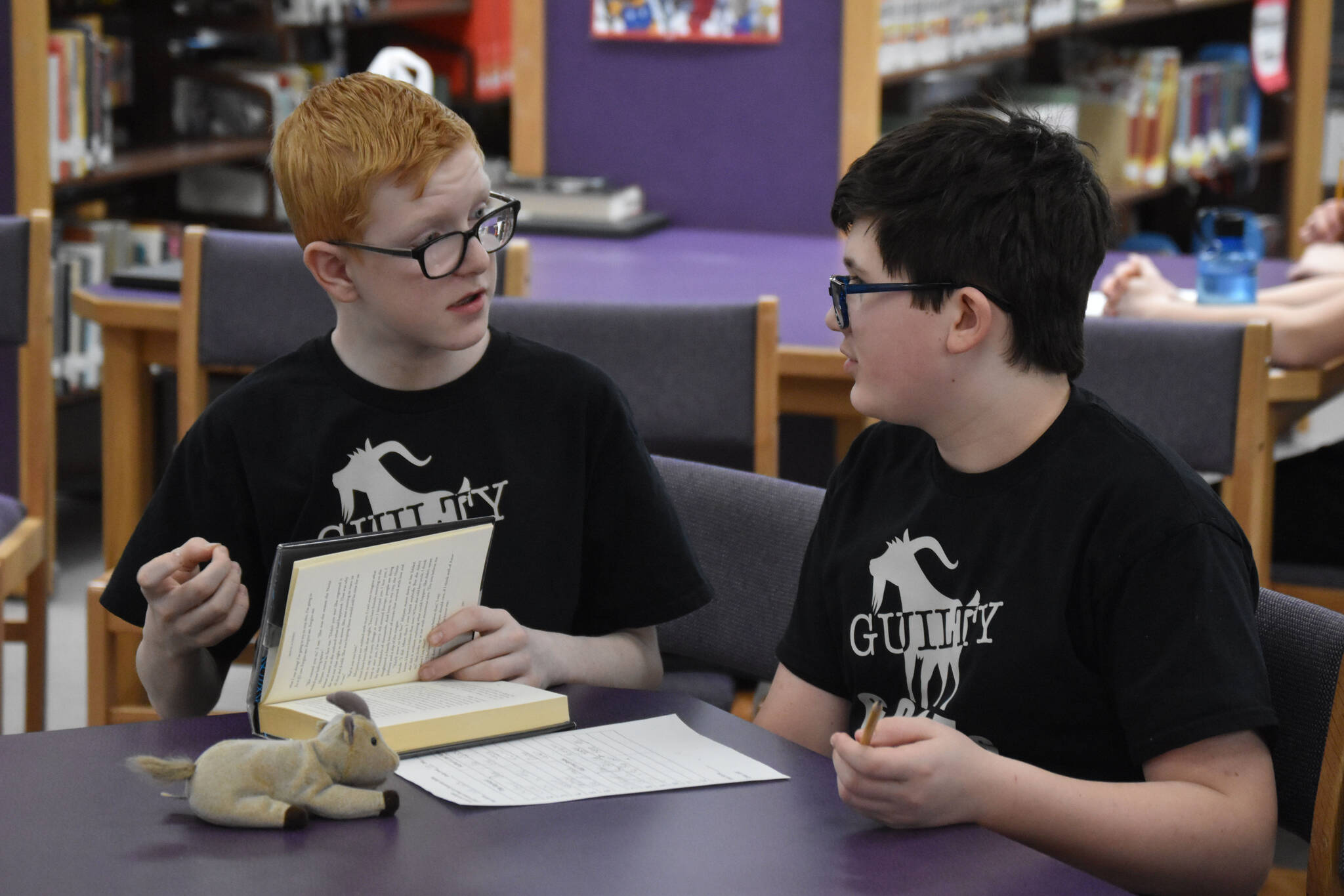 Alan Hack and Oscar Marcou discuss the evidence that they will present to support a challenge issued during Kenai Peninsula Borough School District Middle School Battle of the Books competition on Thursday, Feb. 9, 2023, at Kenai Middle School in Kenai, Alaska. The challenge would ultimately be declared successful. (Jake Dye/Peninsula Clarion)