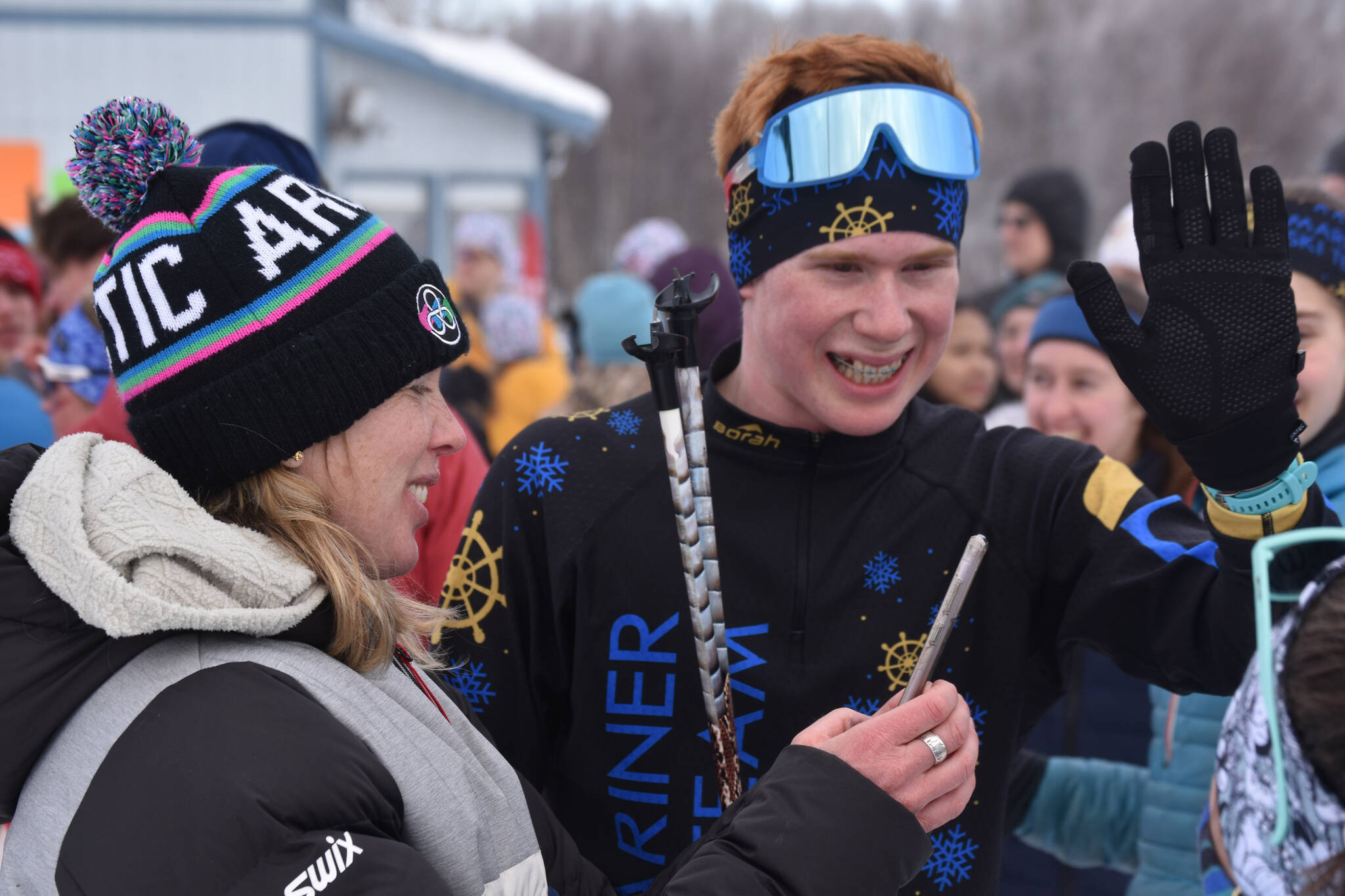 Jody Goodrich reaches out for a high five and smiles alongside Jessie Goodrich, his mother and coach, after he completed the final leg of the boys 4x5-kilometer relay and secured the Homer boys’ program-first Division II win at the ASAA State Nordic Ski Championships at Kincaid Park in Anchorage, Alaska, on Saturday, Feb. 25, 2023.