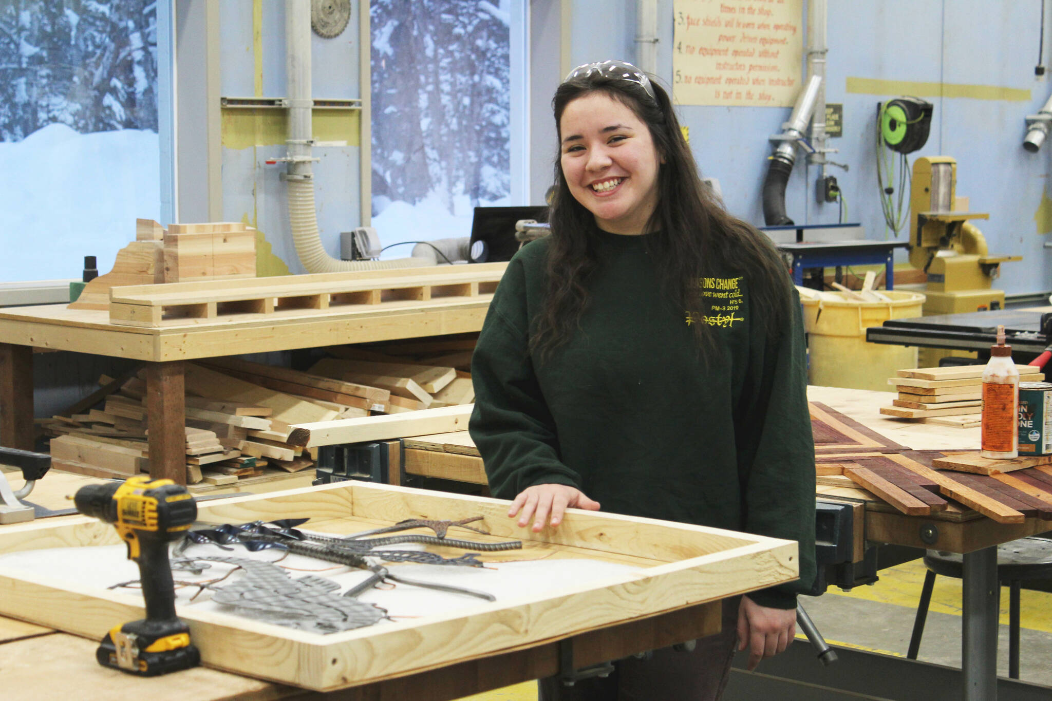 Kenai Central High School senior Jorgi Phillips stands next to a wooden box she made to transport metal art on Wednesday, Feb. 22, 2023 in Kenai, Alaska. (Ashlyn O’Hara/Peninsula Clarion)