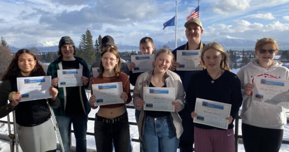 Mariners on the Move 2023 awardees pose with awards at Homer High School on March 1, 2023, in Homer, Alaska. From left to right: Faith Latham, Coleman Stephens, Luke Hanson (back row), Ethan Rodasti (front row), Tait Ostrom, Autumn Jones, Charles Van Meter (back row), Hannah Stonorov, Marilyn Brewer-Cote. (Photo courtesy Paul Story)
