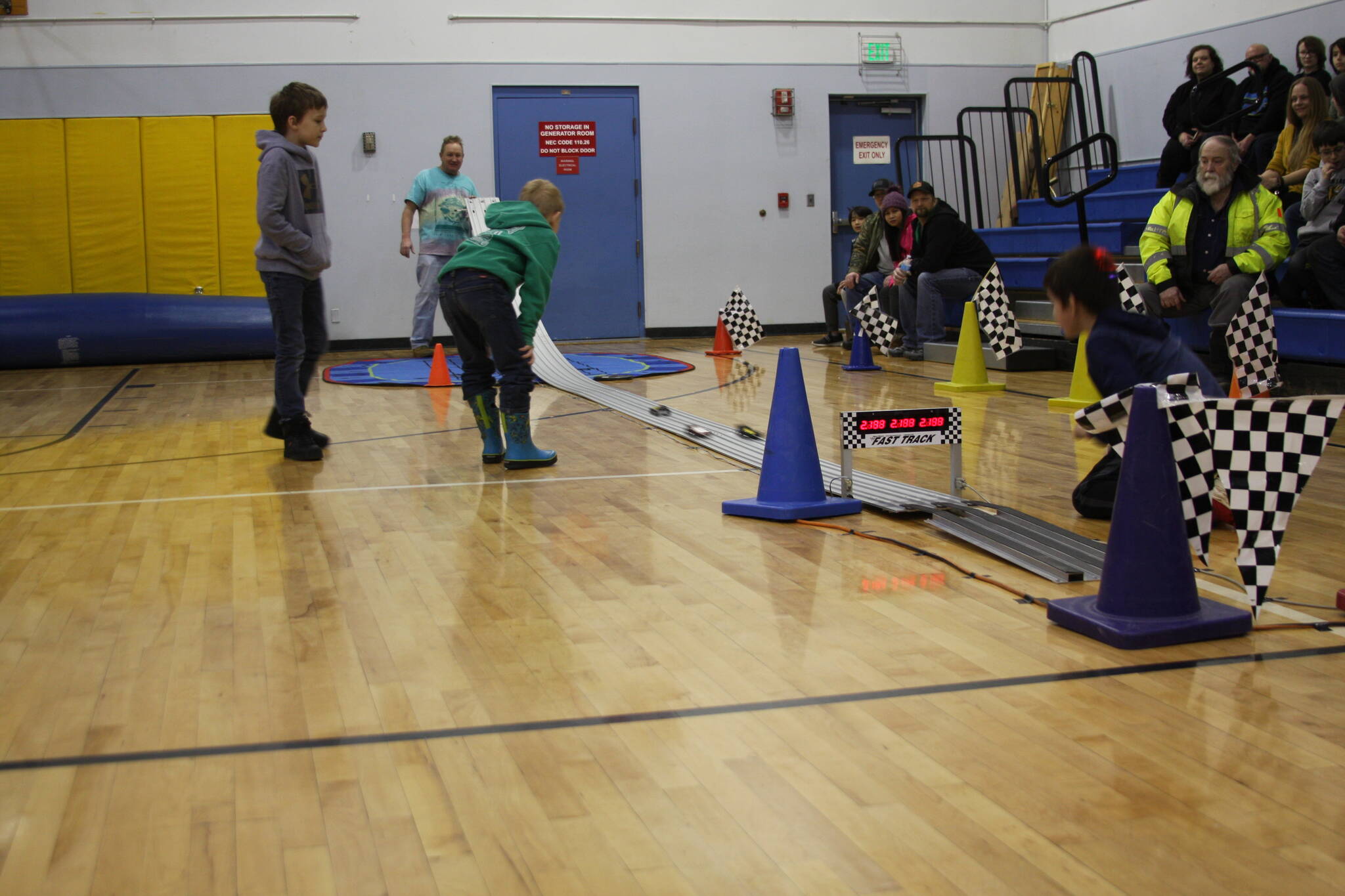 Pinewood derby contestants wait for their cars to cross the finish line in the Chapman School gym during the Snow Rondi on Saturday<ins>,</ins><ins> March 4</ins> in Anchor Point<ins>,</ins> <ins>Alaska</ins>. (Photo by Delcenia Cosman/Homer News)