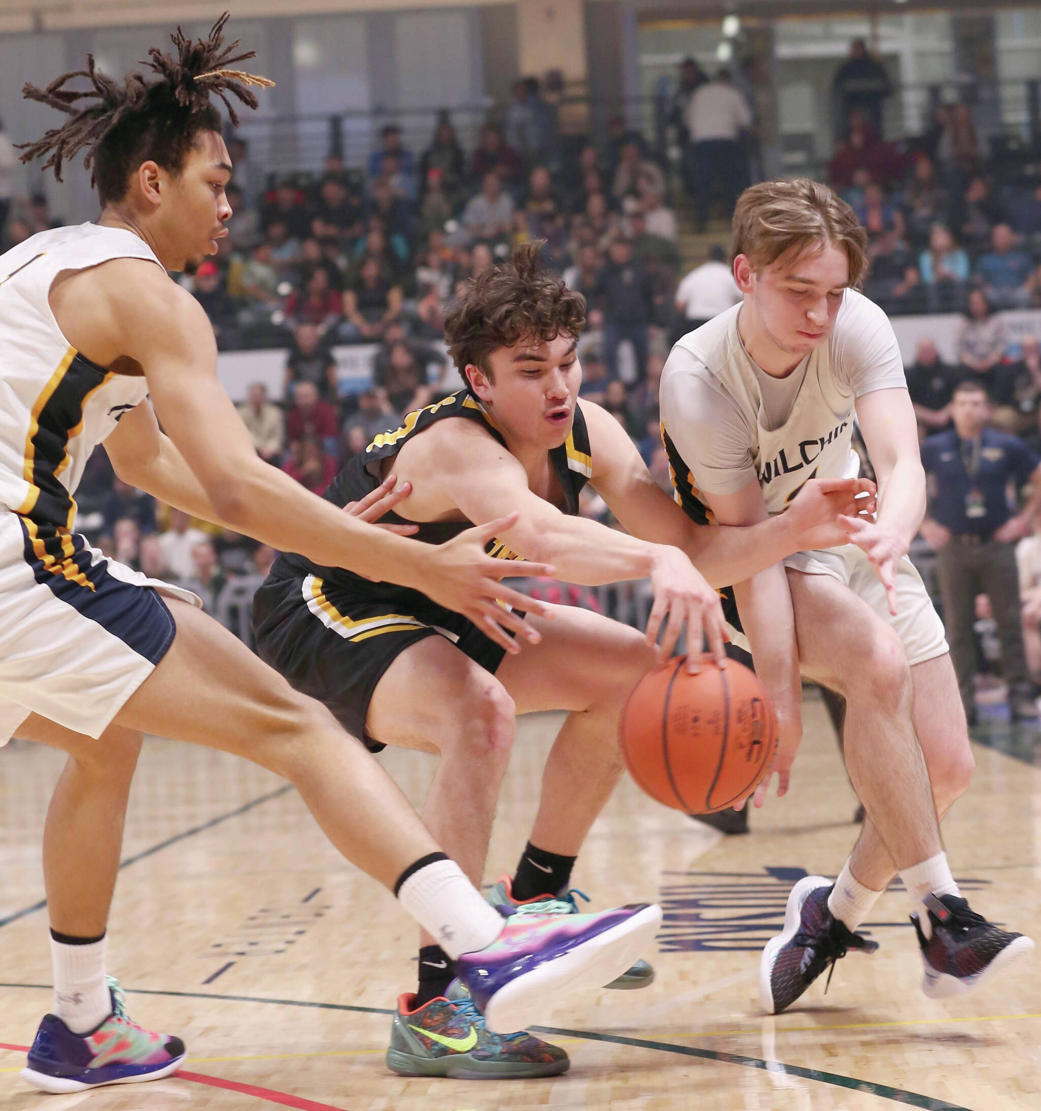 Ninilchik’s Jaylin Scott and Peyton Edens and Aqquilluk Hank of Tikigaq battle for the ball in the Class 2A boys state championship game Saturday, March 18, 2023, at the Alaska Airlines Center in Anchorage, Alaska. (Photo courtesy of Robin Moore)