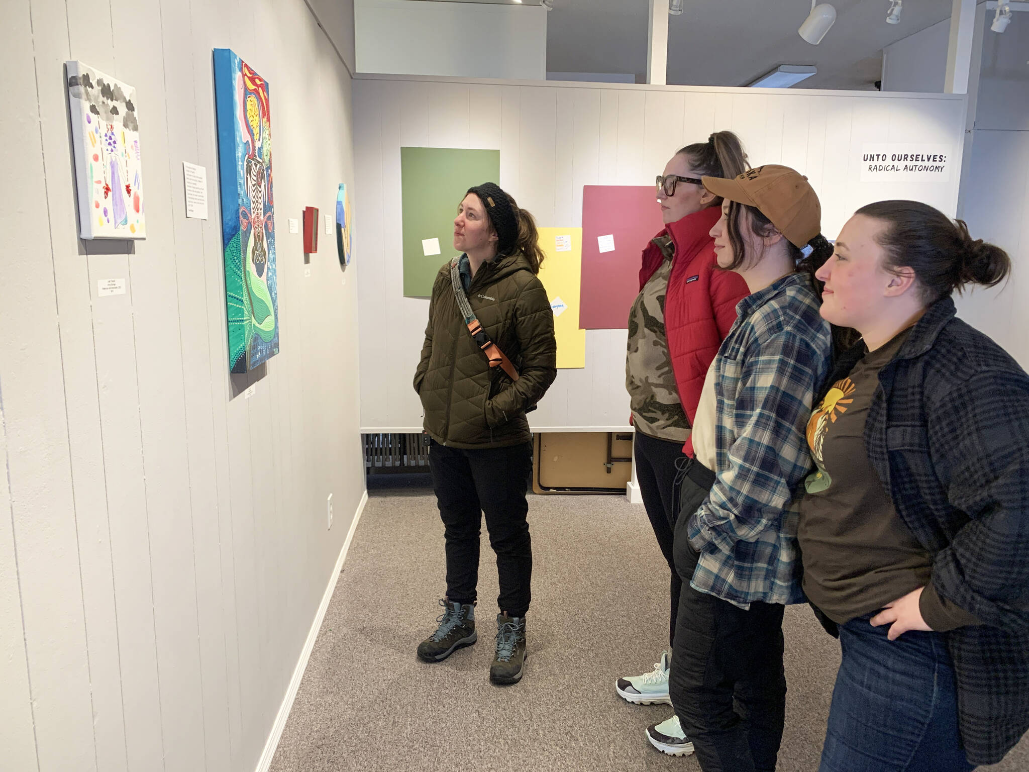 A group of young women visiting Homer take in the “Bodily Autonomy” exhibit at Homer Council on the Arts on March 15. (Photo by Christina Whiting/Homer News)