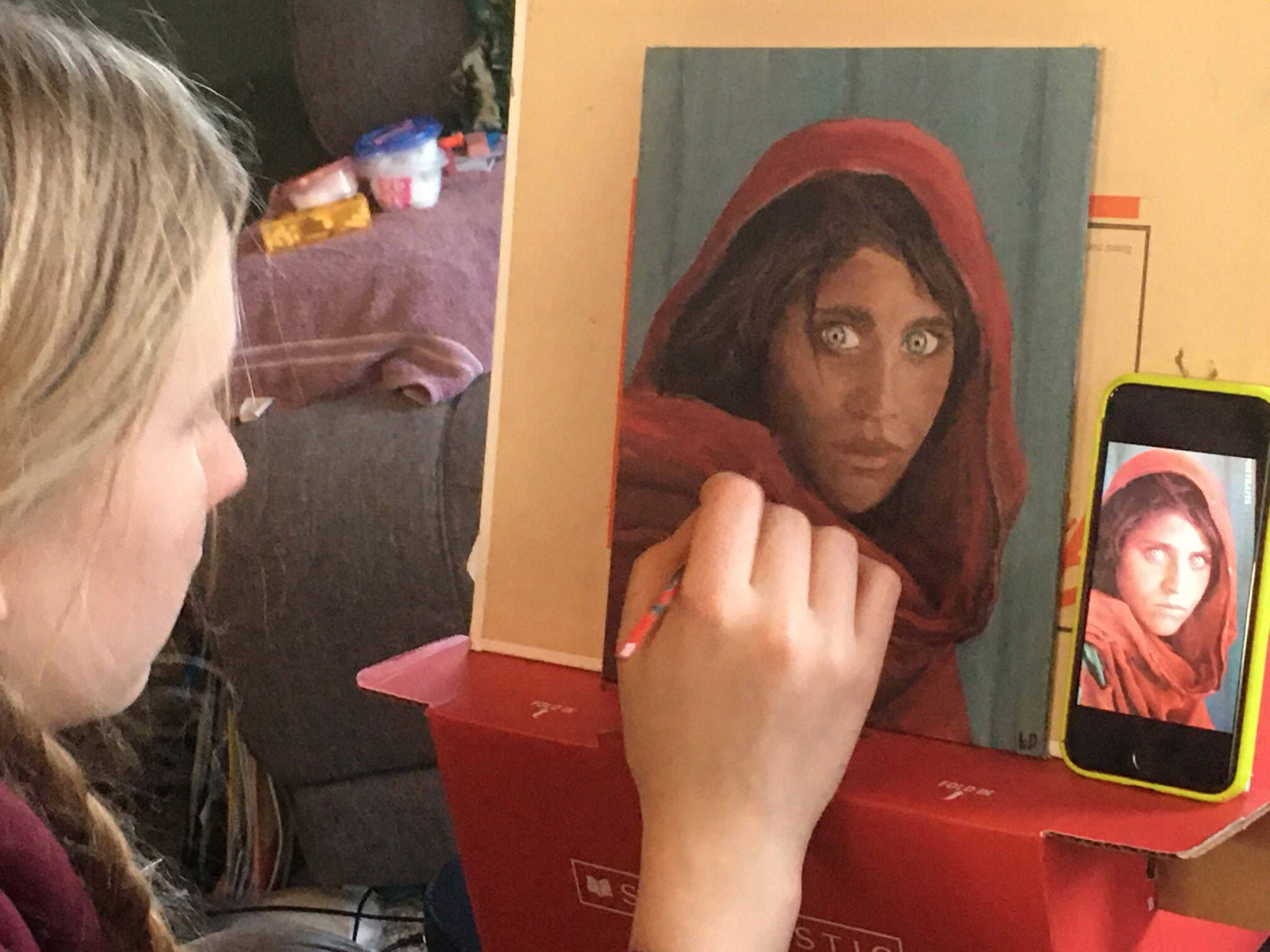 Photo provided by Leah Dunn
Homer youth artist Leah Dunn working on a painting from the famous 1984 “Afghan Girl” originally portrayed on the cover of National Geographic.