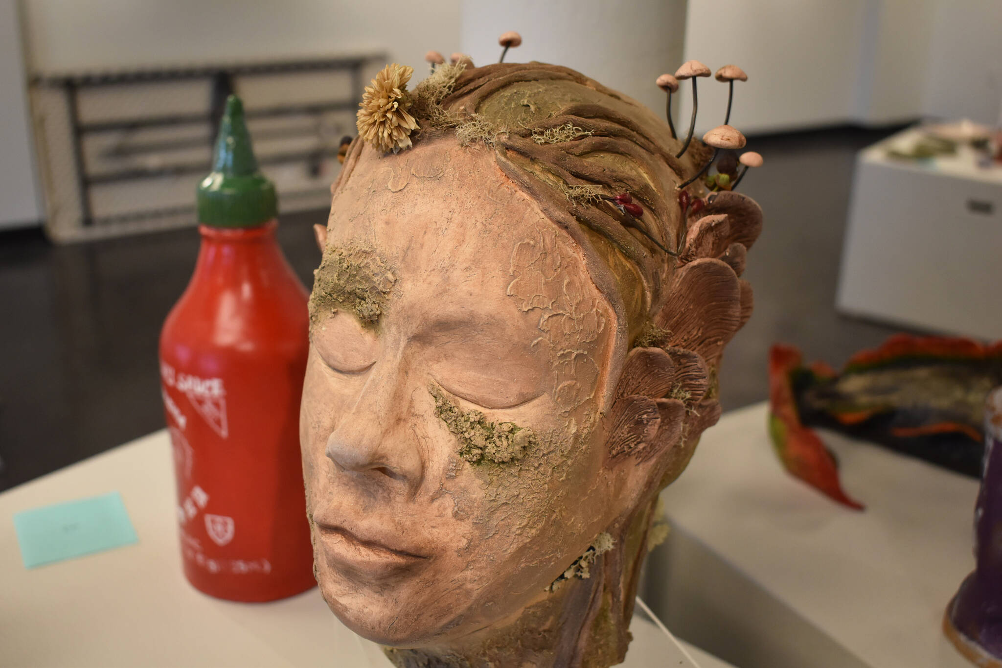 A detailed sculpture of a human head overgrown with fungus rests on a plinth at the Kenai Art Center in Kenai, Alaska on Wednesday, April 5, 2023, in preparation for the debut of the 32nd Annual Kenai Peninsula Borough School District Visual Feast. (Jake Dye/Peninsula Clarion)