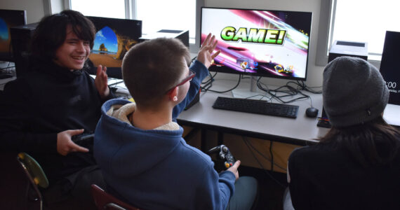 Eli Castro, Blake Gillis and Kaizen Fuller either celebrate victory or cry out in defeat at the end of a practice match of Super Smash Bros. Ultimate played ahead of a scheduled game at Kenai Central High School in Kenai, Alaska, on Wednesday, Feb. 15, 2023. (Jake Dye/Peninsula Clarion)