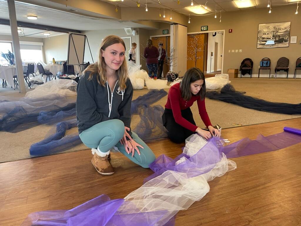 Goldie Hill and Lily Kuhn prepare ceiling decorations for Homer High School prom at Land’s End Resort on Friday. (Photo by Emilie Springer/ Homer News)