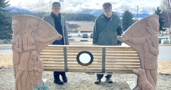 Homer artists Art Koeninger (left) and Brad Hughes (right) stand in front of the Loved and Lost Memorial Bench on April 26, 2023 during a ceremony in which the newly-installed lotus lamp was turned on. Photo by Christina Whiting