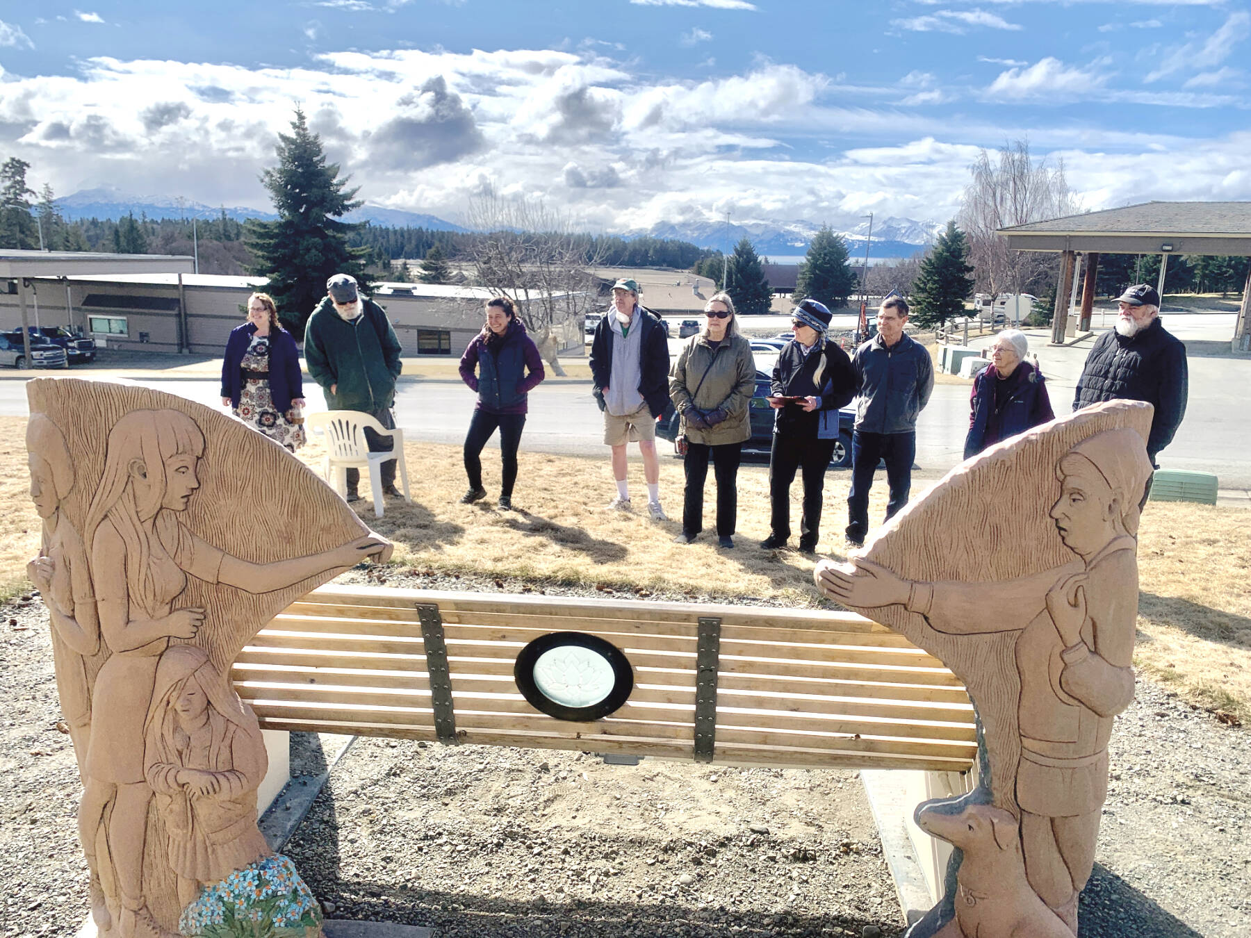 Community members gathered around the Loved and Lost Memorial Bench in front of the Homer Public Library on Wednesday, April 26 to celebrate the installation of the etched glass and copper lotus lamp envisioned by Brad Hughes and created by Art Koeninger. The ceremony, which honored the memory of Anesha “Duffy” Murnane who went missing on Oct. 17, 2019 as well as other missing and murdered people, began with the reading of a poem, “Holding the Light” by Stuart Kestenbaum, then continued with words shared by Murnane’s parents, friends and the artists, and ended with a blessing. The bench was dedicated in a memorial on June 12, 2022, and with the installation of the lamp and the information plaque inside the library’s front doors, the Loved and Lost Memorial Bench is now complete. Photo by Christina Whiting