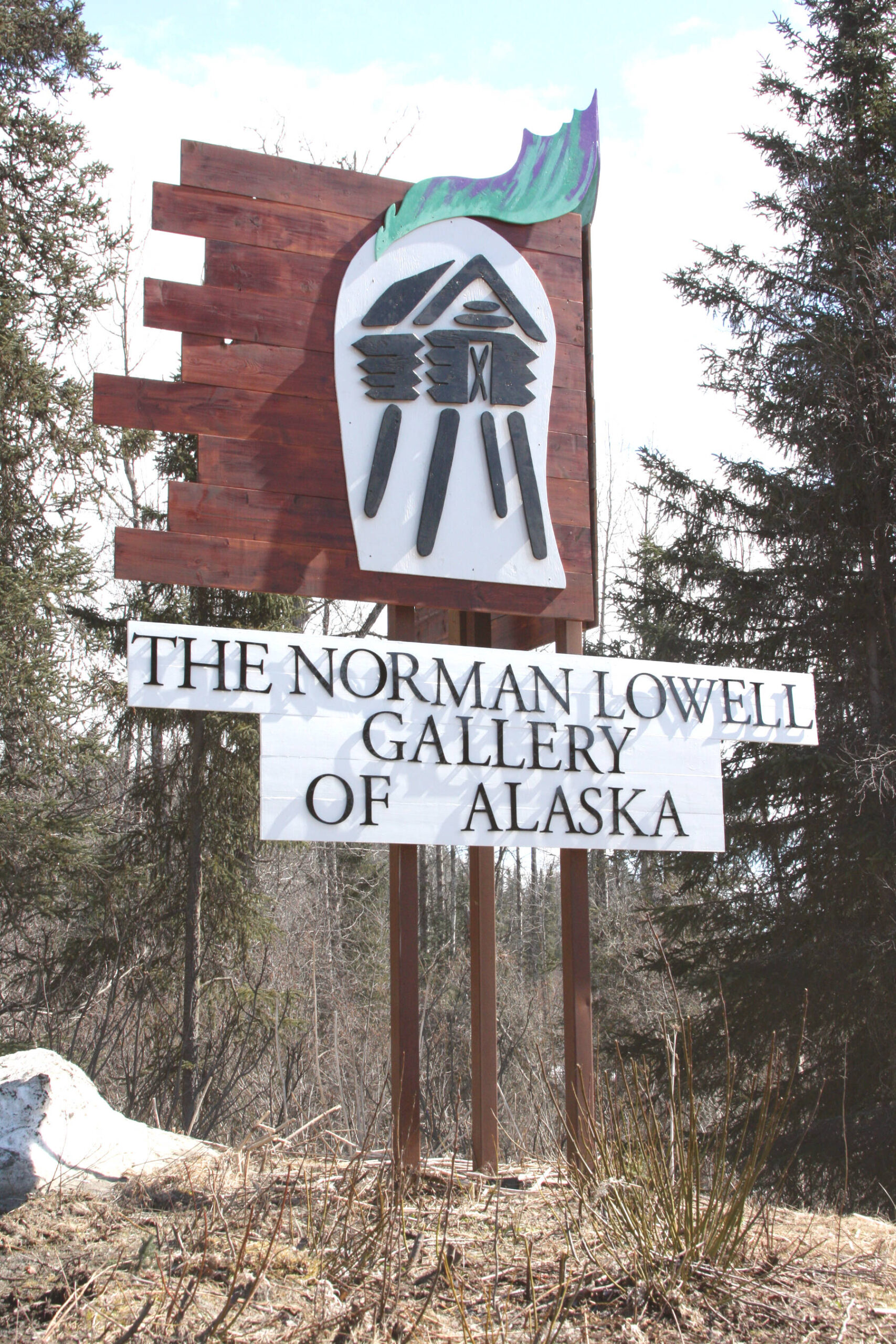 The newly-built sign for the Norman Lowell art gallery sits next to the Sterling Highway at the entrance of Norman Lowell Road between Homer and Anchor Point, Alaska. Photo by Delcenia Cosman