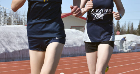 Homer’s Daisy Walker and Soldotna’s Sophia Jedlicki race the 3,200 on Saturday, April 29, 2023, at Ed Hollier Field at Kenai Central High School in Kenai, Alaska. (Photo by Jeff Helminiak/Peninsula Clarion)