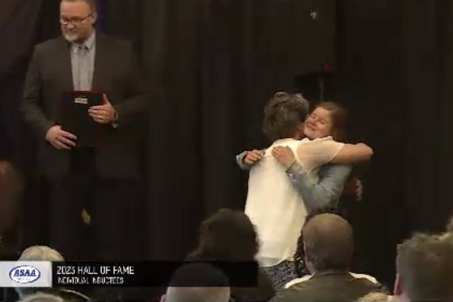 Allie Ostrander and Stacia Rustad share an embrace at the Alaska High School Hall of Fame’s Class of 2023 induction ceremony on Sunday, May 7, 2023, at The Lakefront Hotel in Anchorage, Alaska. (Screenshot)