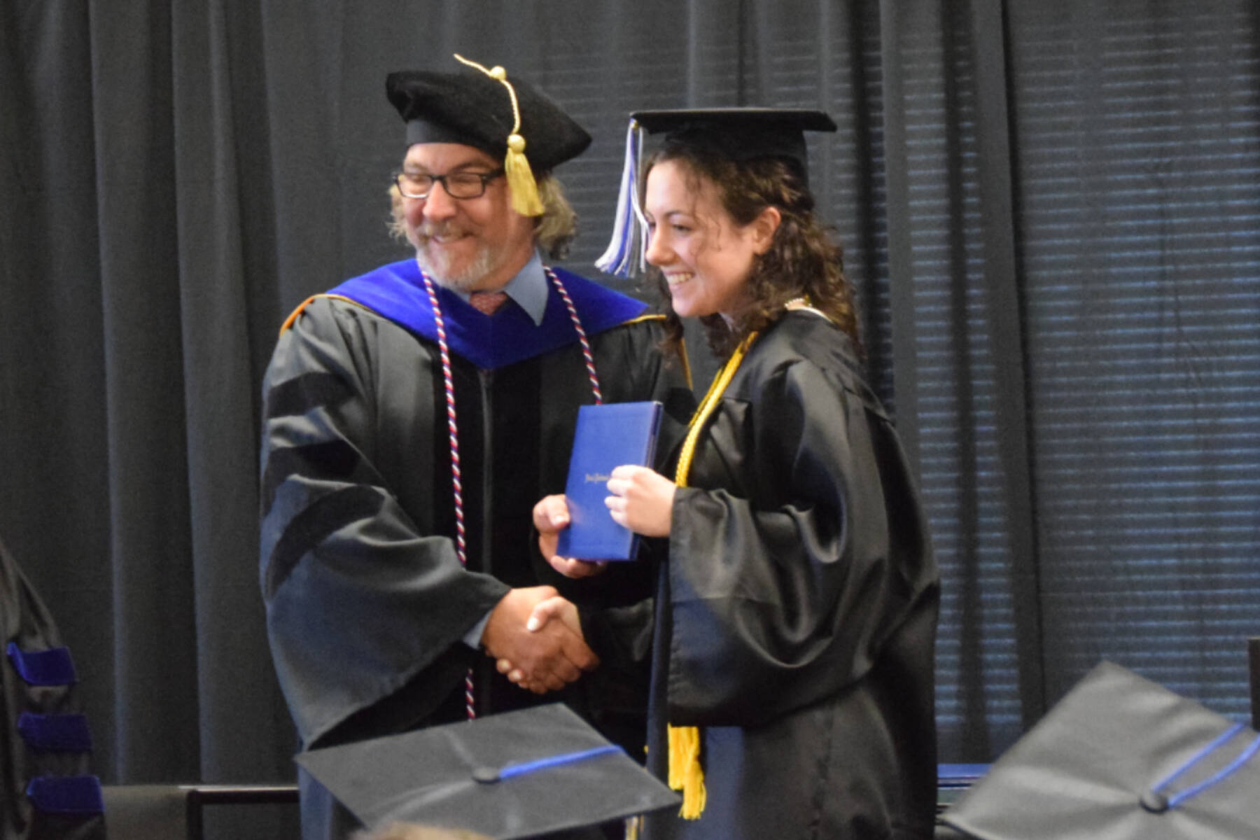 Kachemak Bay Campus Director Dr. Reid Brewer (left) presents valedictorian Elizabeth Rozeboom (right) with her Associate of Arts diploma during the 2023 KBC Commencement on Wednesday, May 10, 2023, in Homer, Alaska. (Photo by Delcenia Cosman/Homer News)