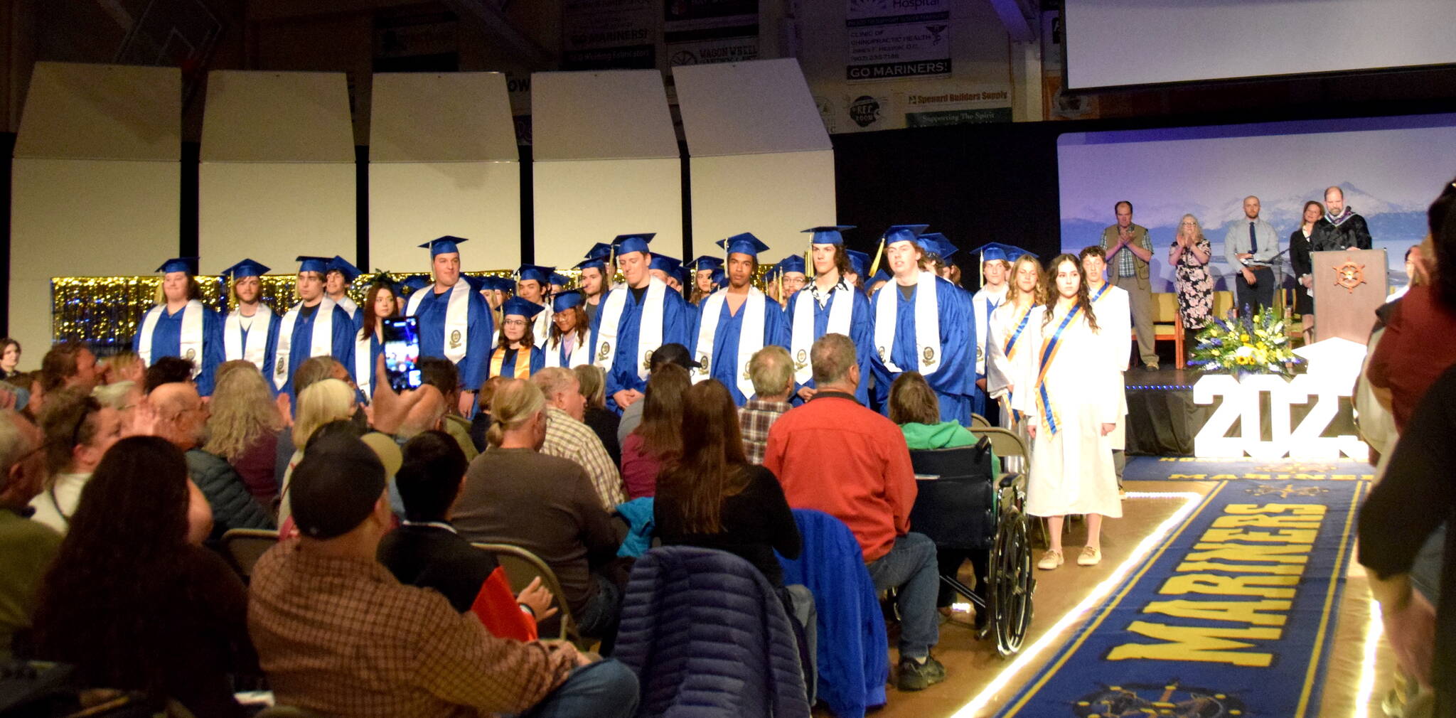 Homer High School 2023 graduating seniors stand during commencement in the Homer High School’s Alice Witte Gymnasium, May 15, 2023, in Homer, Alaska. (Photo by  Emilie Springer/ Homer News)
