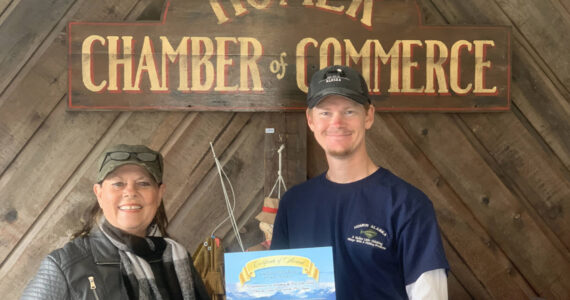 Terry Busch (left) and her son, Aaron Busch, from California pick up an End of the Road certificate at the Homer Chamber of Commerce Spit Visitor Center on Thursday, May 25, 2023 in Homer, Alaska. Photo by Christina Whiting