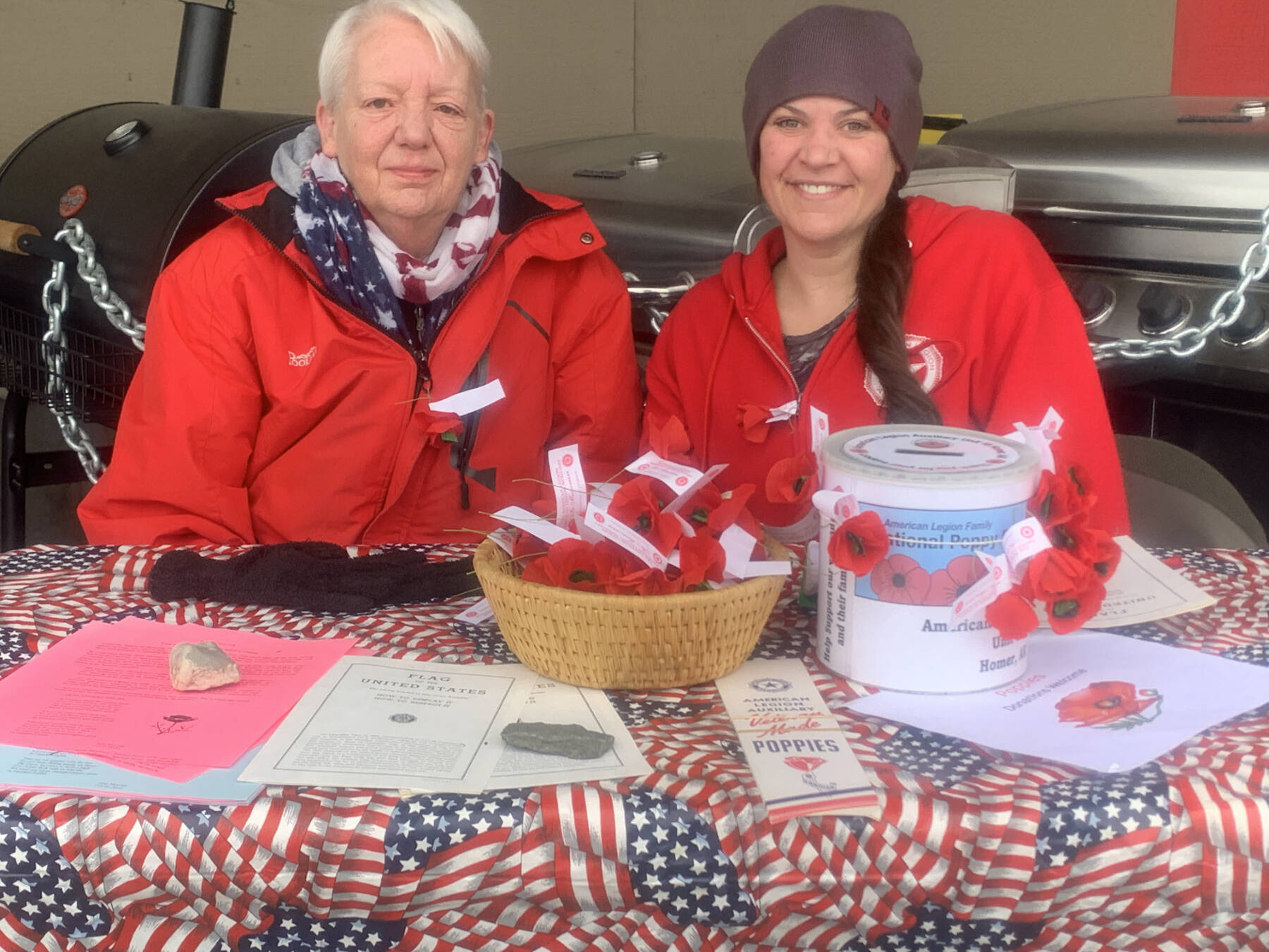 Colleen Wagner and Brianna Bahl distribute paper poppies on Memorial Day weekend outside Safeway on behalf of the American Legion in Homer, Alaska. Photo by Christina Whiting