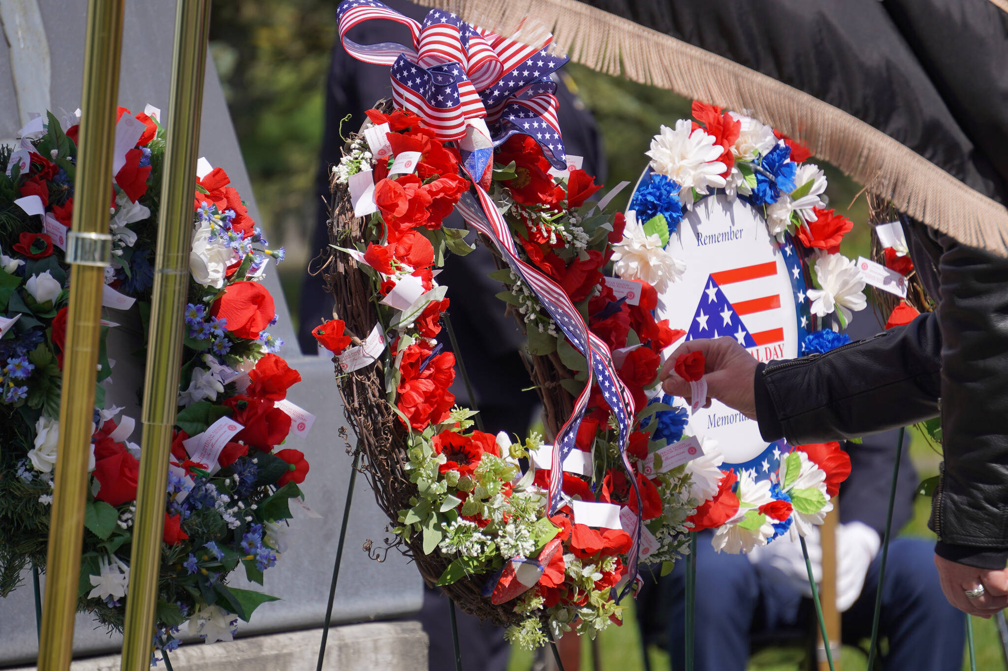 Poppies are affixed to wreaths during a Memorial Day ceremony on Monday, May 29, 2023, at Leif Hanson Memorial Park in Kenai, Alaska. (Jake Dye/Peninsula Clarion)