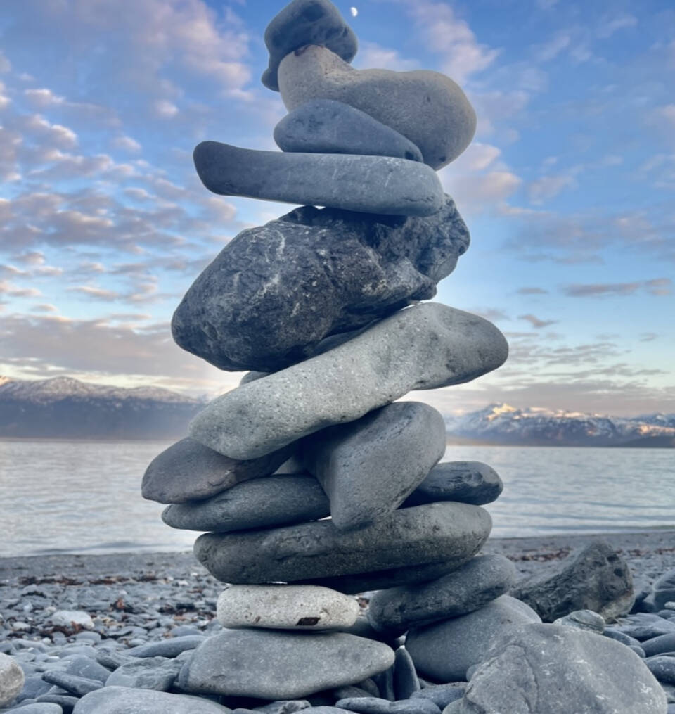 A rock cairn and half moon are pictured on Tuesday, May 30, 2023 at the Land’s End Resort beach in Homer, Alaska. Photo by Christina Whiting