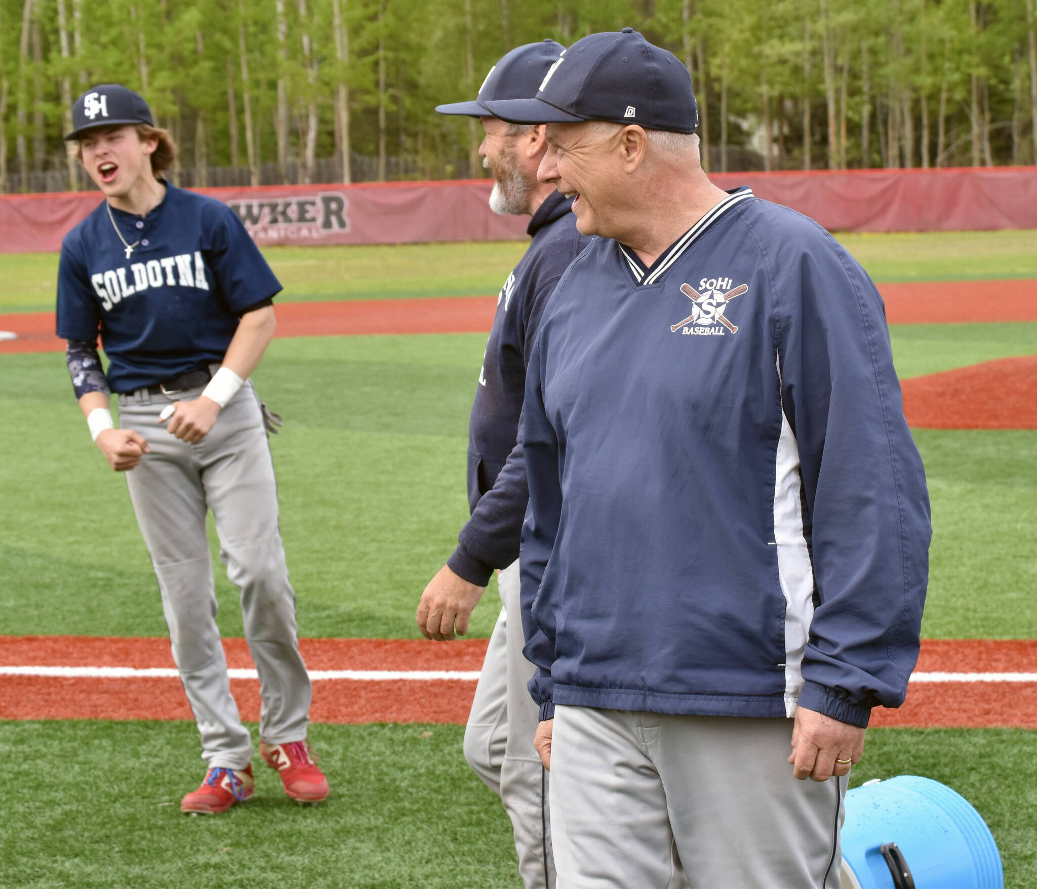 Soldotna head coach Ken Gibson (center) and assistant Charles Mickelson laugh after escaping a celebratory dump of ice water, but Easton Hawkins still celebrates after the Division II state championship game Saturday, June 4, 2023, at Wasilla High School in Wasilla, Alaska. (Photo by Jeff Helminiak/Peninsula Clarion)
